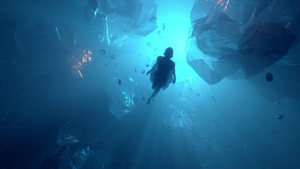 Silhouette diving into deep blue dreamlike water surrounded by symbolic shapes representing the collective unconscious.